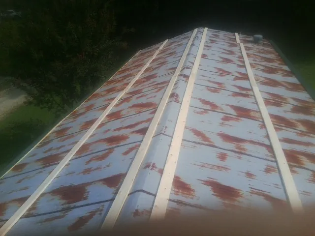 Rusted metal roof panels with new wood purlins before replacement — Storm Damage Roof Repair in Belleville by Roofing Brothers