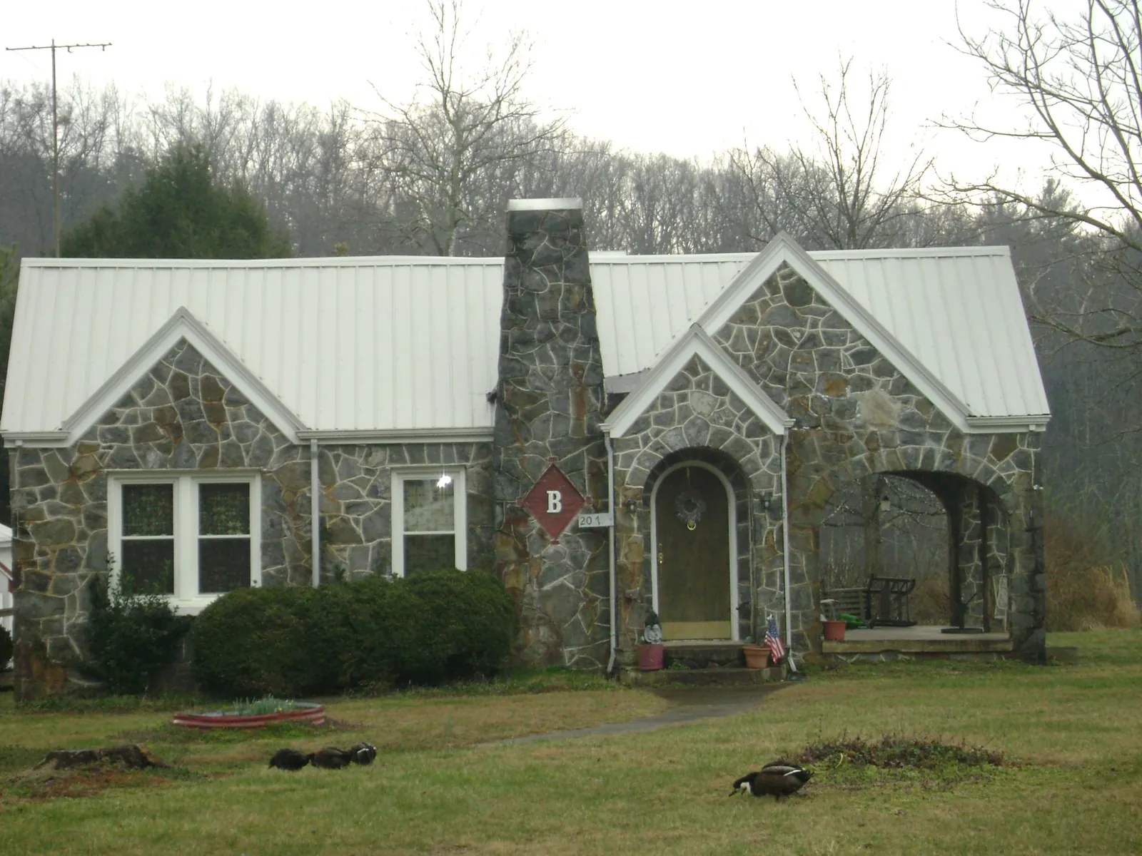 White metal roof on a stone cottage with steep gables in Belleville