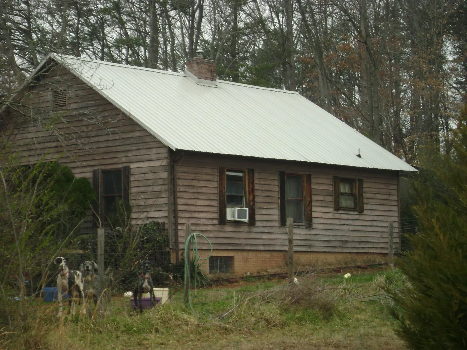 White metal roof on an old wood sided farmhouse, from a Metal Roof Installation job in Belleville
